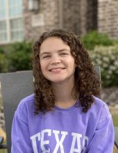 Emily Pearson A young lady in a purple sweat shirt smiling.