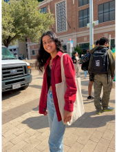 A  young lady in a red long sleeve smiling.